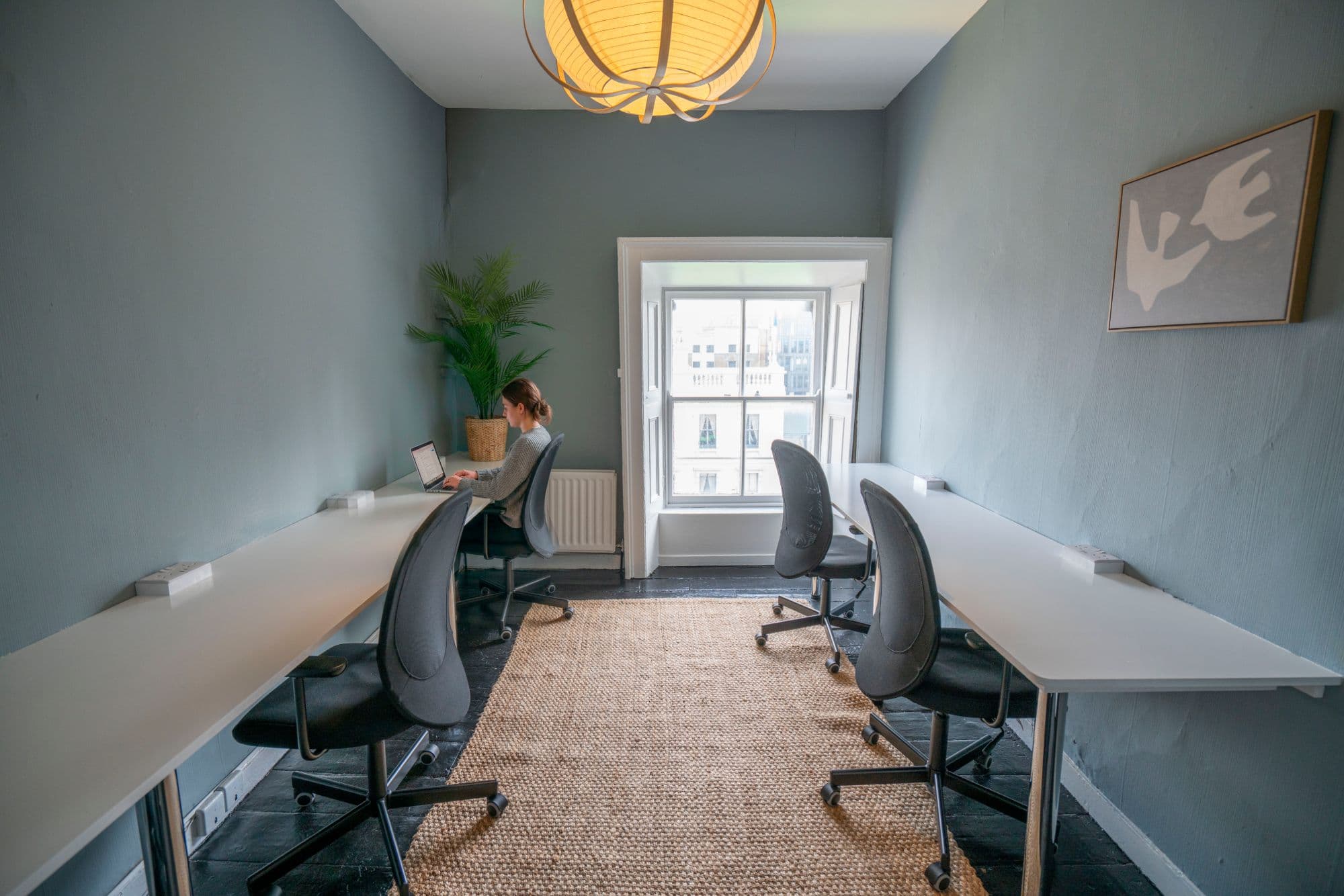 A member working at a desk in a bright workspace